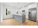 Bright kitchen featuring white cabinetry, a gray island, stainless steel appliances, and natural light at 3924 Hager Dr, Charlotte, NC 28208