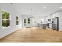 Spacious living room showcasing natural light, modern lighting, and sleek, light-colored hardwood floors at 3924 Hager Dr, Charlotte, NC 28208