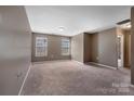 An empty bedroom includes neutral carpet, light-colored walls and two windows allowing natural light in at 5008 Social Cir, Fort Mill, SC 29707