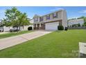 Inviting two-story home showcasing a lush green lawn and a spacious driveway leading to a two-car garage at 5008 Social Cir, Fort Mill, SC 29707
