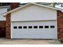 This garage features white paneled doors, and attached brick facade at 7448 Forney Hill Rd, Denver, NC 28037