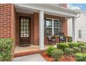 Inviting front porch with rocking chairs, white columns and a well landscaped garden at 8115 Wilburn Ct, Charlotte, NC 28277