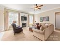 Bright and airy living room featuring a fireplace, large windows, and comfortable seating at 8115 Wilburn Ct, Charlotte, NC 28277