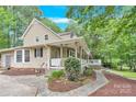 Side view showcasing the home's architecture, stone pathway, and lush greenery, highlighting its peaceful setting at 832 Kemp Rd, Mooresville, NC 28117