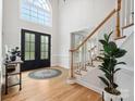 Bright foyer with hardwood floors, a staircase with white railings, and a soaring window above the door at 8921 Whittingham Dr, Waxhaw, NC 28173