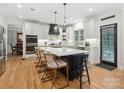 Gourmet kitchen boasting a large island with seating, stainless steel appliances, and sleek white cabinets at 8921 Whittingham Dr, Waxhaw, NC 28173