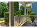 View of the spacious front porch with white railings and a stylish outdoor rug with shade at 9227 Island Overlook Ct, Cornelius, NC 28031