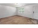 Bright and airy living room features neutral carpet and natural light at 9612 Old Dowd Rd, Charlotte, NC 28214
