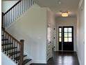Welcoming foyer with hardwood floors, a staircase with iron railings, and a view of the front door at 102 Cartington Way # Haf0042, Mooresville, NC 28115