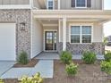 Inviting front porch with a glass door, stylish brick accents, and manicured landscaping, creating curb appeal at 102 Cartington Way # Haf0042, Mooresville, NC 28115