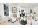 Open living space with a modern sofa, bright windows, and a view into the kitchen at 1116 4Th St, Statesville, NC 28677