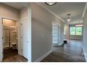 Hallway showcasing hard wood floors, neutral paint, and entryways to a bathroom and other rooms at 119 Tonbridge Way # Haf0033, Mooresville, NC 28115