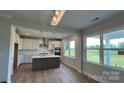 Kitchen features modern appliances, an island with sink, white cabinets, tile backsplash, and ample natural light at 119 Tonbridge Way # Haf0033, Mooresville, NC 28115