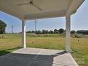 Covered patio features concrete flooring and white pillars, offering a great view of the expansive backyard at 119 Tonbridge Way # Haf0033, Mooresville, NC 28115