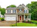 Charming two-story home boasts a well-manicured lawn and inviting front porch with white pillars at 1206 Craig Ave, Lancaster, SC 29720