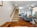 Open-concept living room featuring hardwood floors, a staircase, and seamless flow into the dining area and kitchen at 1206 Craig Ave, Lancaster, SC 29720