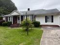 Charming ranch-style home featuring a brick facade, white siding, green lawn, and mature trees at 1292 Longview Rd, Rock Hill, SC 29732