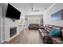 Spacious living room features a fireplace, ceiling fan and wood-look flooring at 15432 Coventry Court Ln, Charlotte, NC 28277