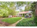 Charming backyard with a stone patio, fire pit, adirondack chairs, and lush landscaping; perfect for outdoor entertaining at 1801 E 8Th St, Charlotte, NC 28204