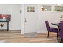 Bright entryway with a white door, decorative rug, and stylish purple dining chairs at 1831 Erie St, Charlotte, NC 28216