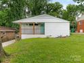 Inviting white brick home with a cheerful turquoise door and well-maintained lawn at 1831 Erie St, Charlotte, NC 28216