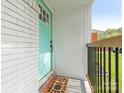 A welcoming turquoise front door with a decorative welcome mat and a sturdy railing at 1831 Erie St, Charlotte, NC 28216