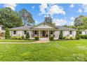 Charming ranch-style home with a manicured lawn, lush landscaping and inviting front porch swings at 227 Wingrave Dr, Charlotte, NC 28270