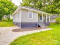 View of the exterior of a home with gray siding, a covered front porch, and a curved driveway at 2440 Myers St, Gastonia, NC 28056