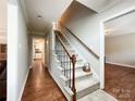 Inviting hallway with a carpeted staircase, wooden handrail, and neutral wall colors at 2619 Quailrush Rd, Charlotte, NC 28226
