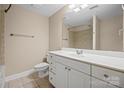 Standard bathroom with a white vanity, sink, toilet, and a large mirror over the vanity at 300 W 5Th St # 812, Charlotte, NC 28202