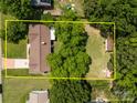 Aerial view of the property featuring the roof, large backyard, and surrounding trees at 303 Jean Ave, Kannapolis, NC 28083
