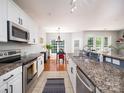 Galley kitchen with granite countertops, stainless steel appliances, and bright lighting at 3248 Margellina Dr, Charlotte, NC 28210
