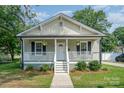 Charming home with a covered front porch, decorative railings, and flower baskets at 330 Central Ave, Kannapolis, NC 28081