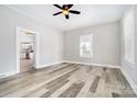 Spacious living room with new wood-look flooring, neutral paint, and a ceiling fan at 330 Central Ave, Kannapolis, NC 28081