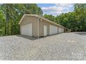 View of a three-car garage with easy access and lots of storage, surrounded by a peaceful, wooded area at 364 Luther Dr, Iron Station, NC 28080