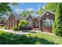 Charming brick home features a well-manicured lawn and a traditional design with black shutters at 3917 Erskine Woods Dr, Bessemer City, NC 28016