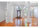 Bright foyer with gleaming hardwood floors, elegant columns, and a decorative front door at 3917 Erskine Woods Dr, Bessemer City, NC 28016