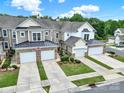 Aerial view of townhomes with garages, driveways, and manicured landscaping at 45008 Wigeon Ln # 202, Indian Land, SC 29707