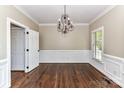 Formal dining room featuring hardwood floors, wainscoting, chandelier, and abundant natural light at 4637 Shannamara Dr, Matthews, NC 28104