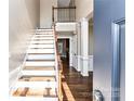Inviting foyer with hardwood floors, staircase, white wainscoting, and natural light at 4637 Shannamara Dr, Matthews, NC 28104