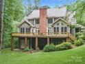 Spacious backyard view showcasing a large wooden deck with seating and a well-maintained lawn at 550 Burrage Ne Rd, Concord, NC 28025