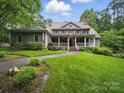 Landscaped front yard with a sidewalk leading up to a beautiful two story home with a covered front porch at 550 Burrage Ne Rd, Concord, NC 28025