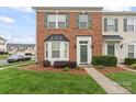 Beautiful brick townhome featuring a well-maintained lawn, bay window and green shutters at 6309 Margaret Ct, Indian Trail, NC 28079