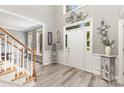 Elegant foyer with wood-look flooring, staircase, high ceilings, decorative accents, and plenty of natural light at 6419 Antioch Ct, Matthews, NC 28104
