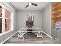Well-lit home office featuring built-in bookshelves, large windows, and modern desk setup at 6419 Antioch Ct, Matthews, NC 28104
