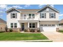 Charming two-story home with a balcony, well-manicured lawn, and stone accents at 7414 Meridale Forest Dr, Charlotte, NC 28269