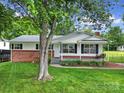 Charming brick and white home with a well-maintained lawn and a cozy front porch swing at 842 Cherry S Rd, Rock Hill, SC 29732