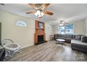 Cozy living room with a brick fireplace, ceiling fans, and laminate flooring at 842 Cherry S Rd, Rock Hill, SC 29732