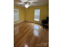 Bright bedroom with hardwood floors, two windows, and a ceiling fan at 8720 Lee St, Mount Pleasant, NC 28124