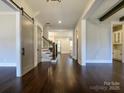 A spacious foyer with hardwood floors, stairs, an open concept, and a sliding barn door at 9426 Greyson Ridge Dr, Charlotte, NC 28277